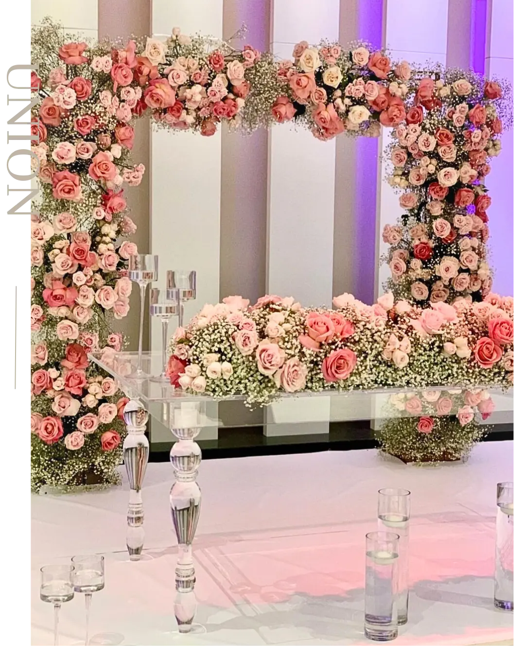 Mur de roses et table d’honneur fleurie pour une réception de mariage
