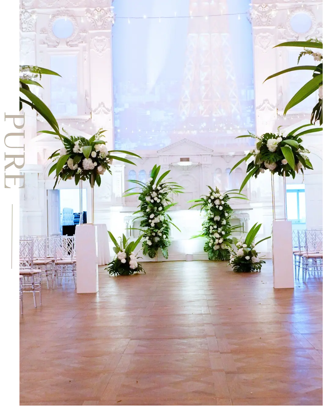 Arrangements floraux blancs le long de l’allée dans une salle de bal lumineuse