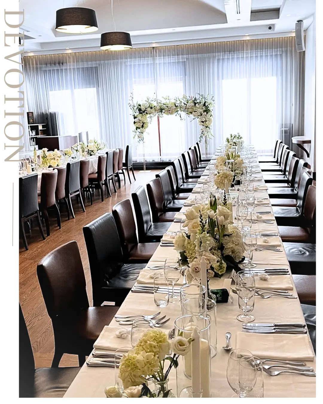 Longue table de réception avec centres de table blancs et arche fleurie