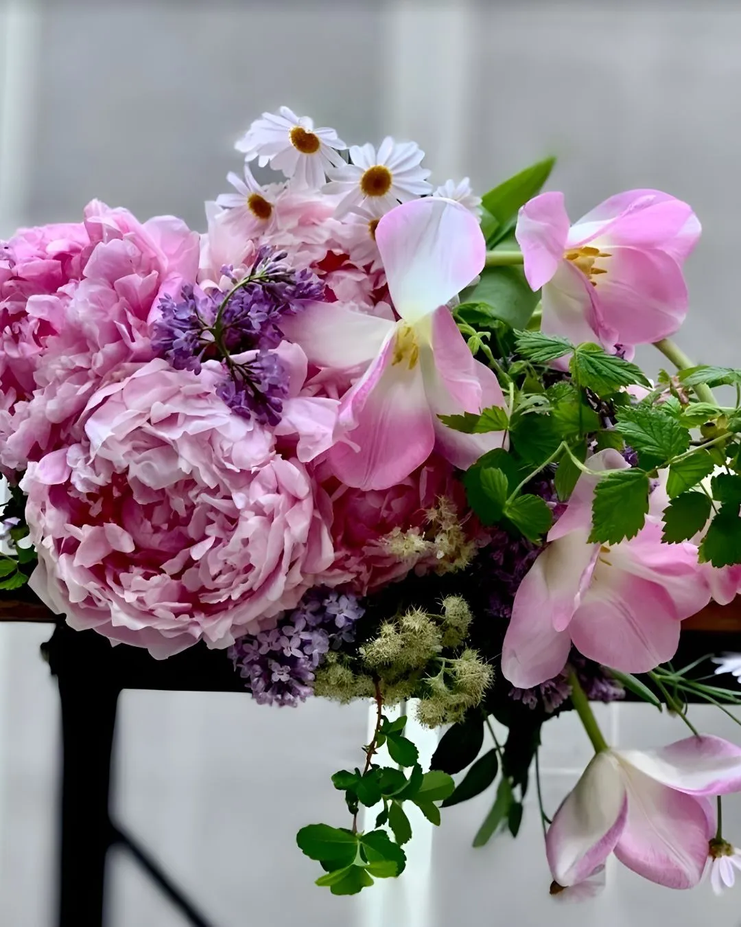 Pink peony, tulip and lilac arrangement with daisies