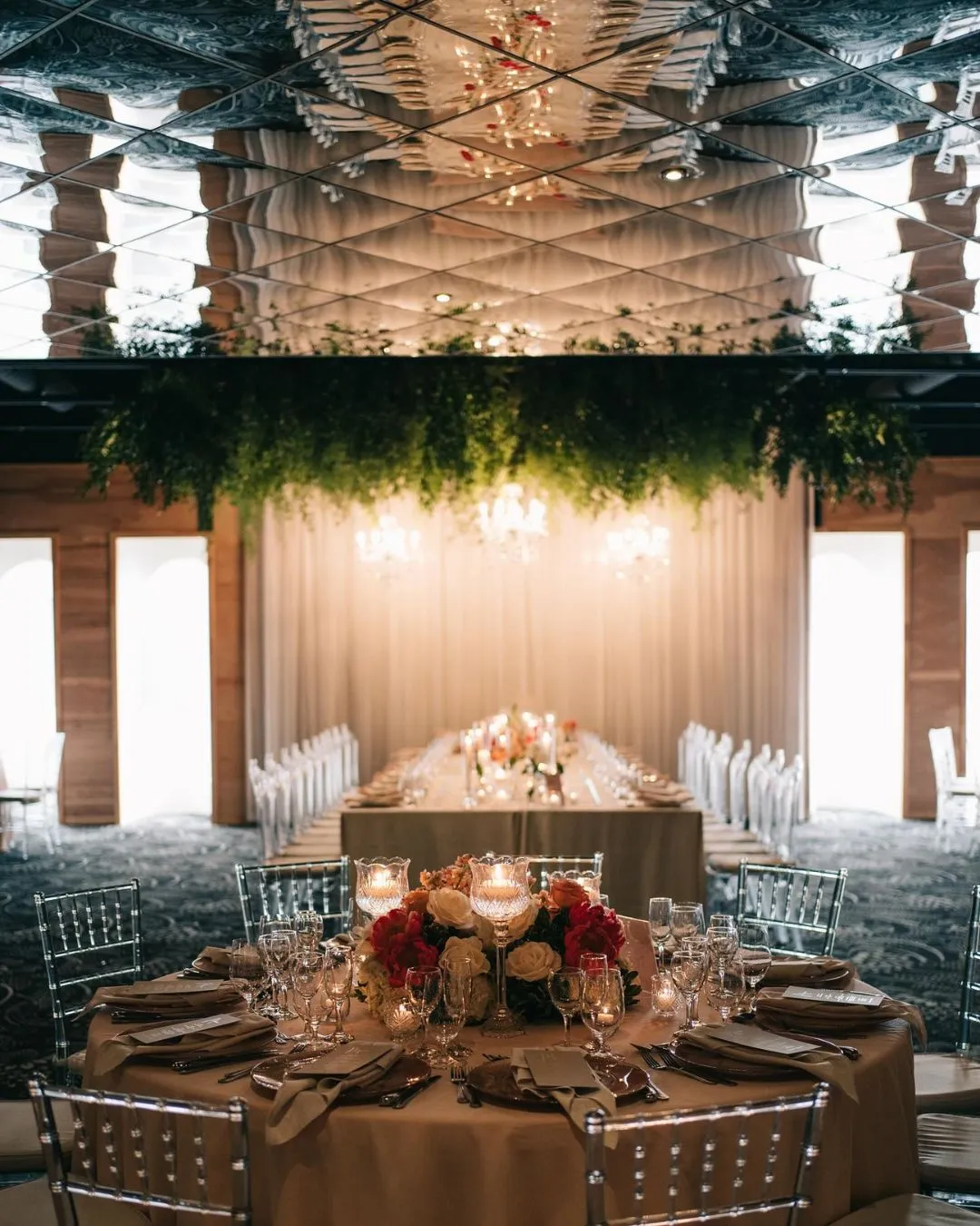 Banquet hall with a hanging greenery installation over the head table