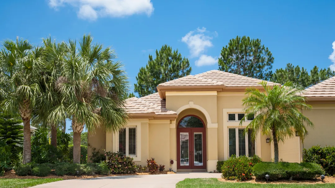 Florida home with a tile roof and palm trees