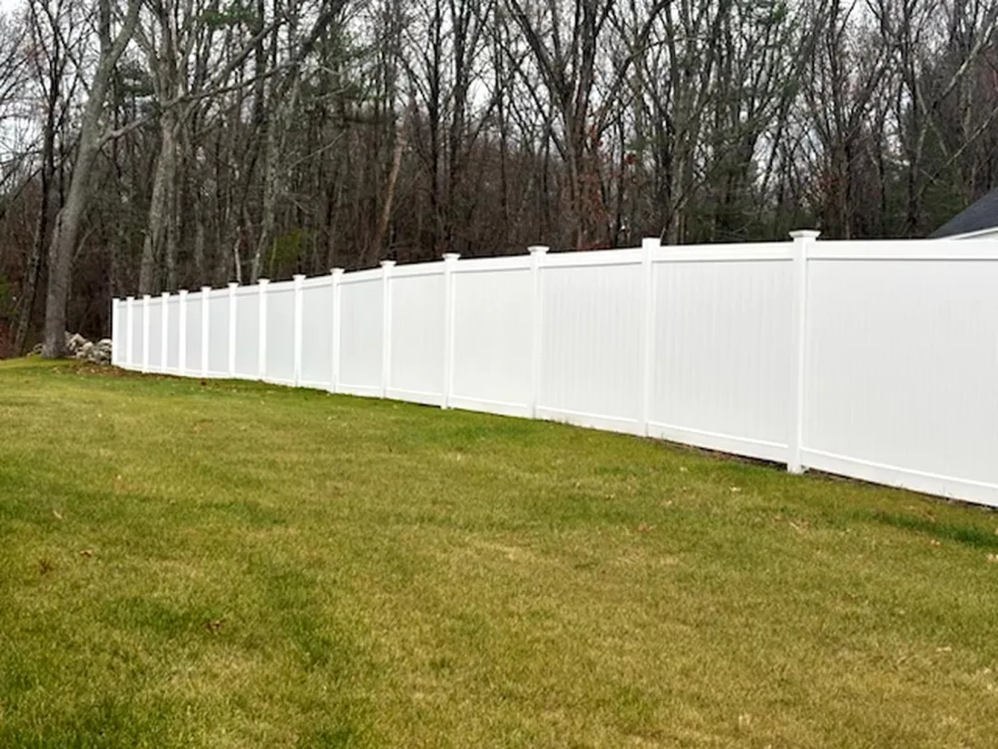 White vinyl fence along a backyard by All Fenced In