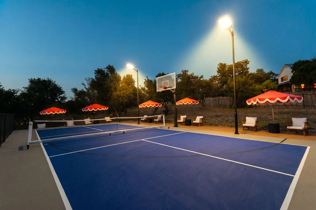 Multi-use court under lights with lounge seating and umbrellas