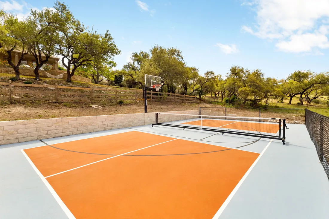 Pickleball court in orange and slate on acreage, wide view