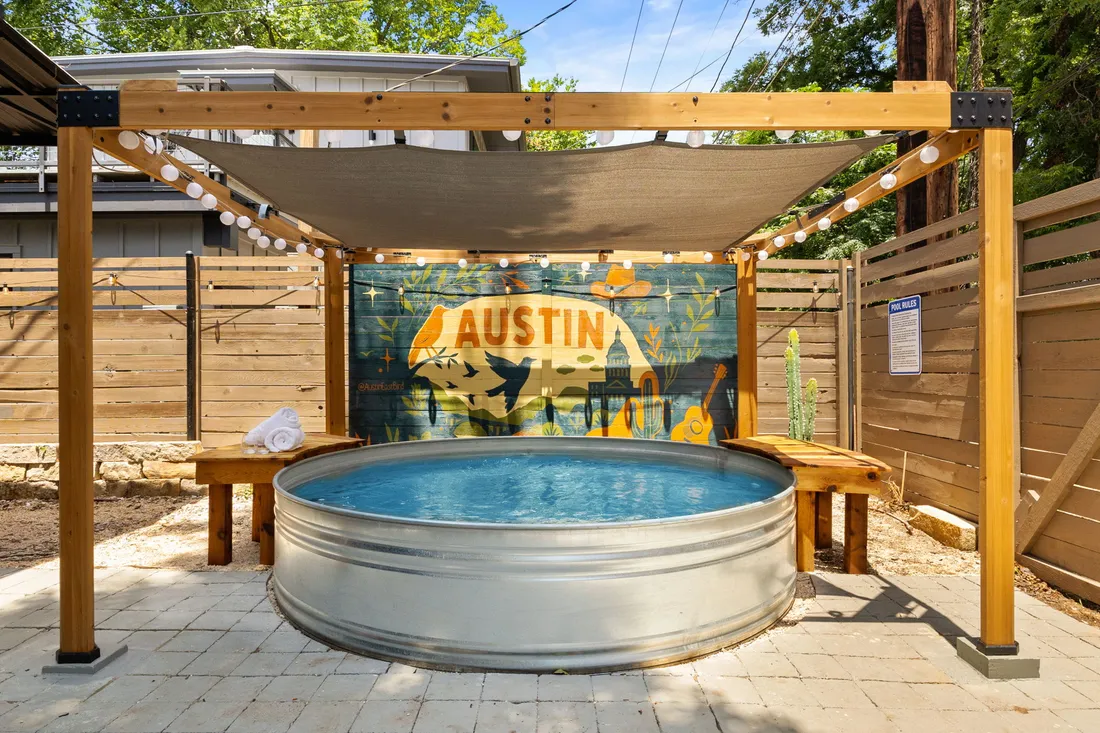 Stock tank pool with cedar pergola and shade sail