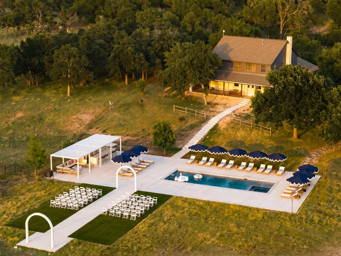 Pool with a pergola and loungers on Hill Country acreage, aerial