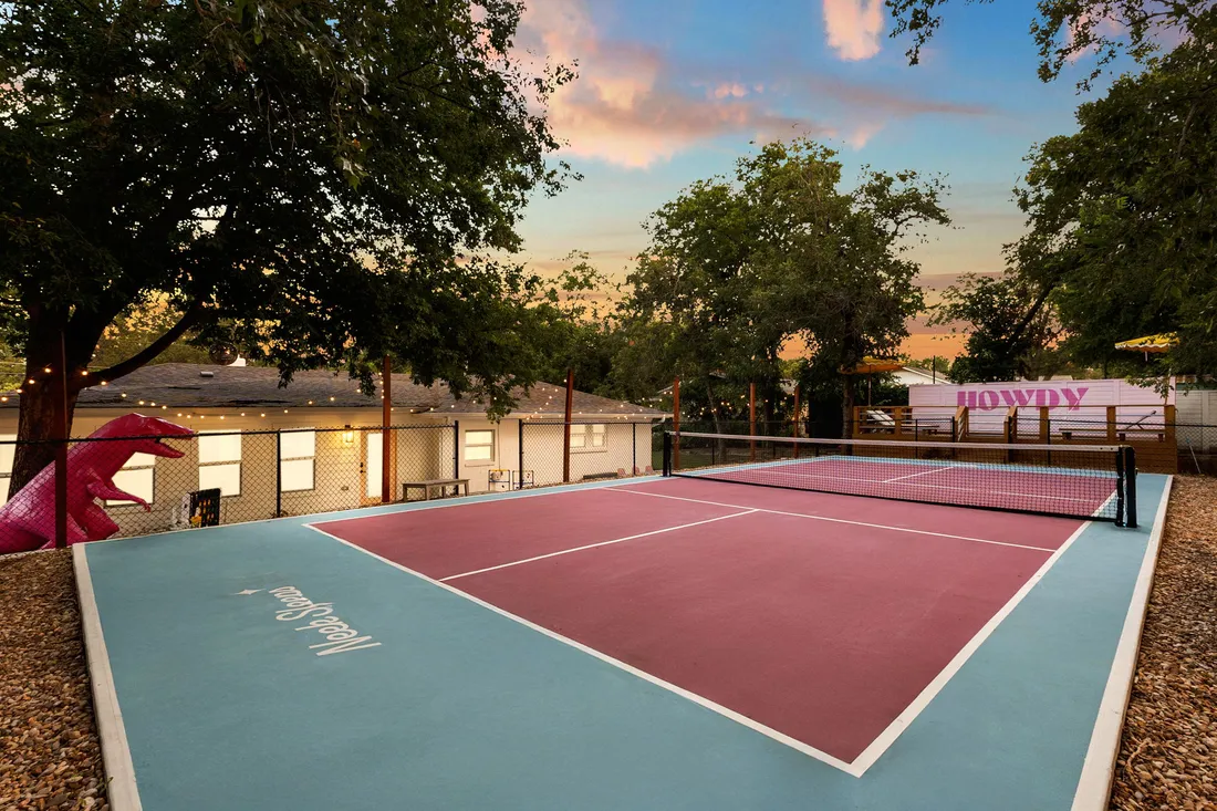 Pickleball court in pink and slate, backyard at dusk
