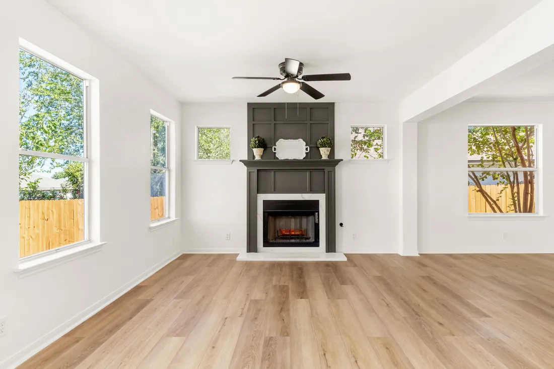 Living room with a paneled fireplace wall and new plank flooring