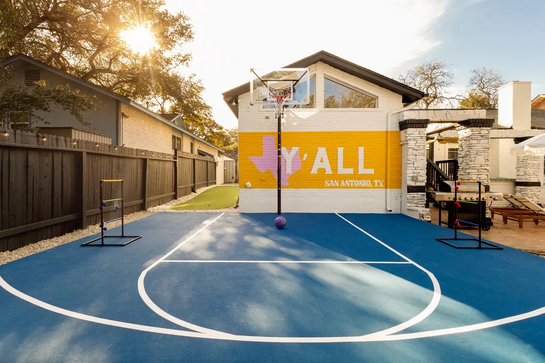 Half-court basketball with ladder toss in front of a painted Y'ALL mural, San Antonio