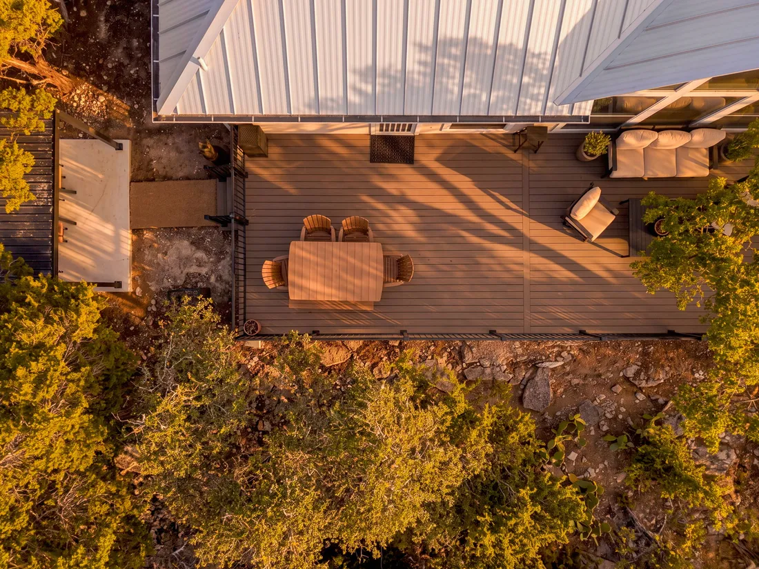 Covered deck on a wooded hillside lot, aerial, Wimberley