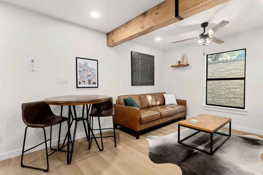 Living room with a cedar beam, leather sofa and new plank flooring