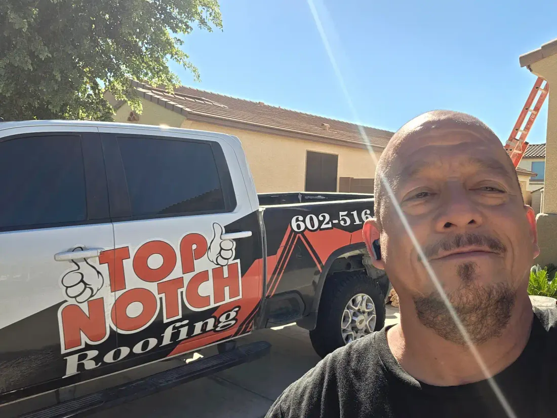 Handy Lanfourd, owner of Top Notch Roofing, next to the company truck