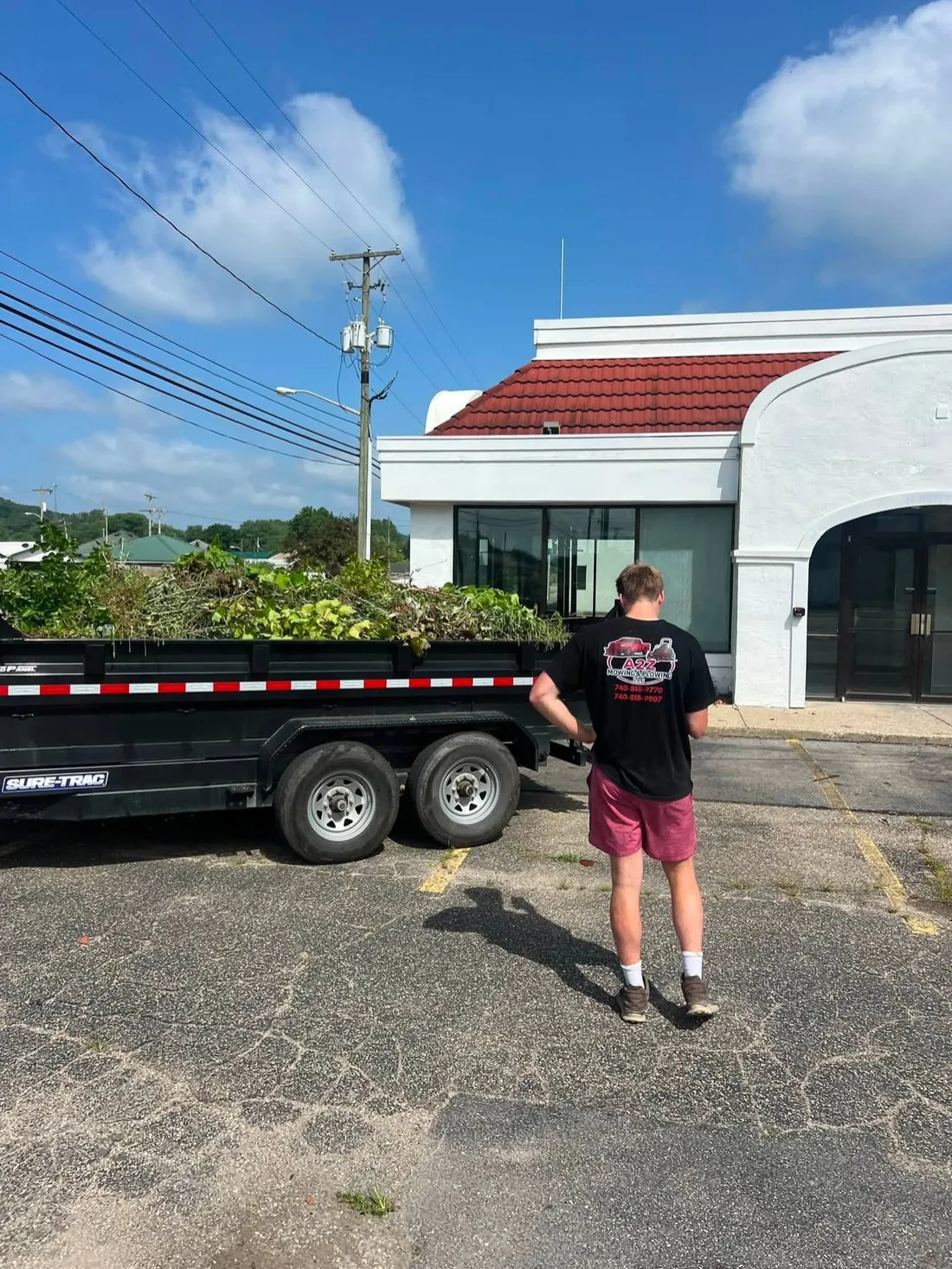 A trailer loaded with brush and yard debris ready to leave the property