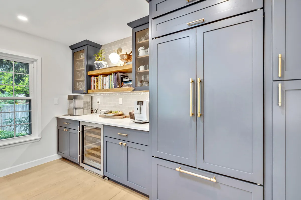 Glencoe Cir main photo — Kitchen remodel featuring navy cabinetry, glass-front displays, open shelving, and gold hardware.