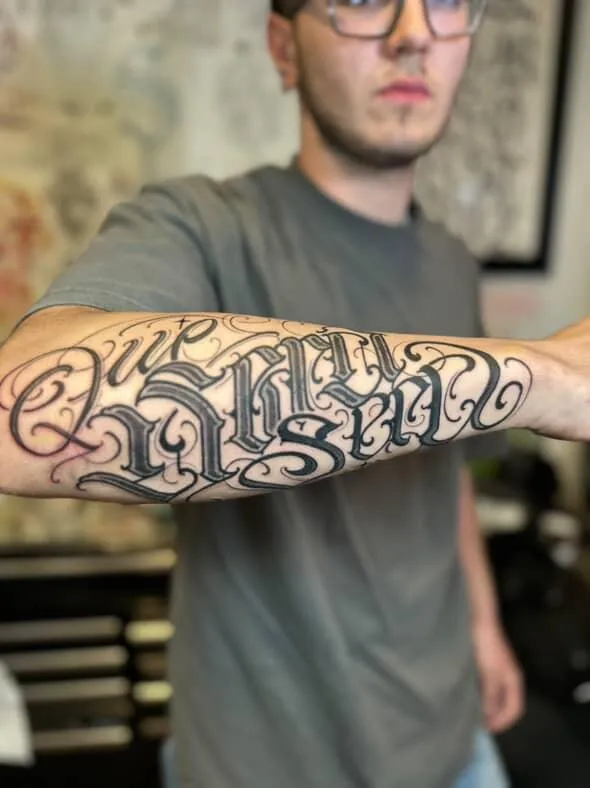 Custom black lettering forearm tattoo by Deft Ink at Montana Tattoo Company in Missoula Montana