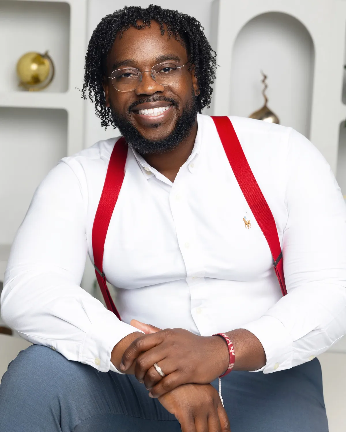 Corey G. Patterson seated in a white shirt and red suspenders