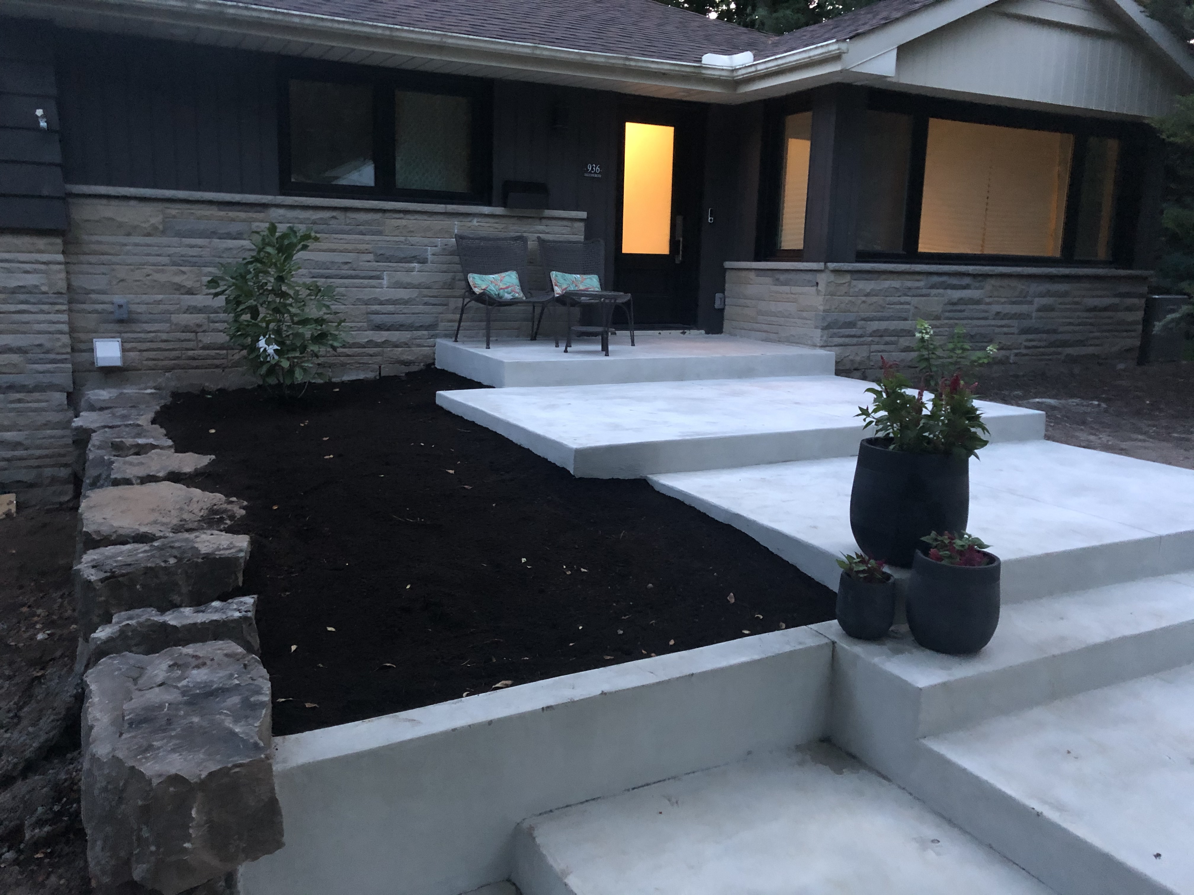 Modern concrete front entrance with steps walkway and custom landscaping completed by SCP Stamped Concrete Pros Inc.