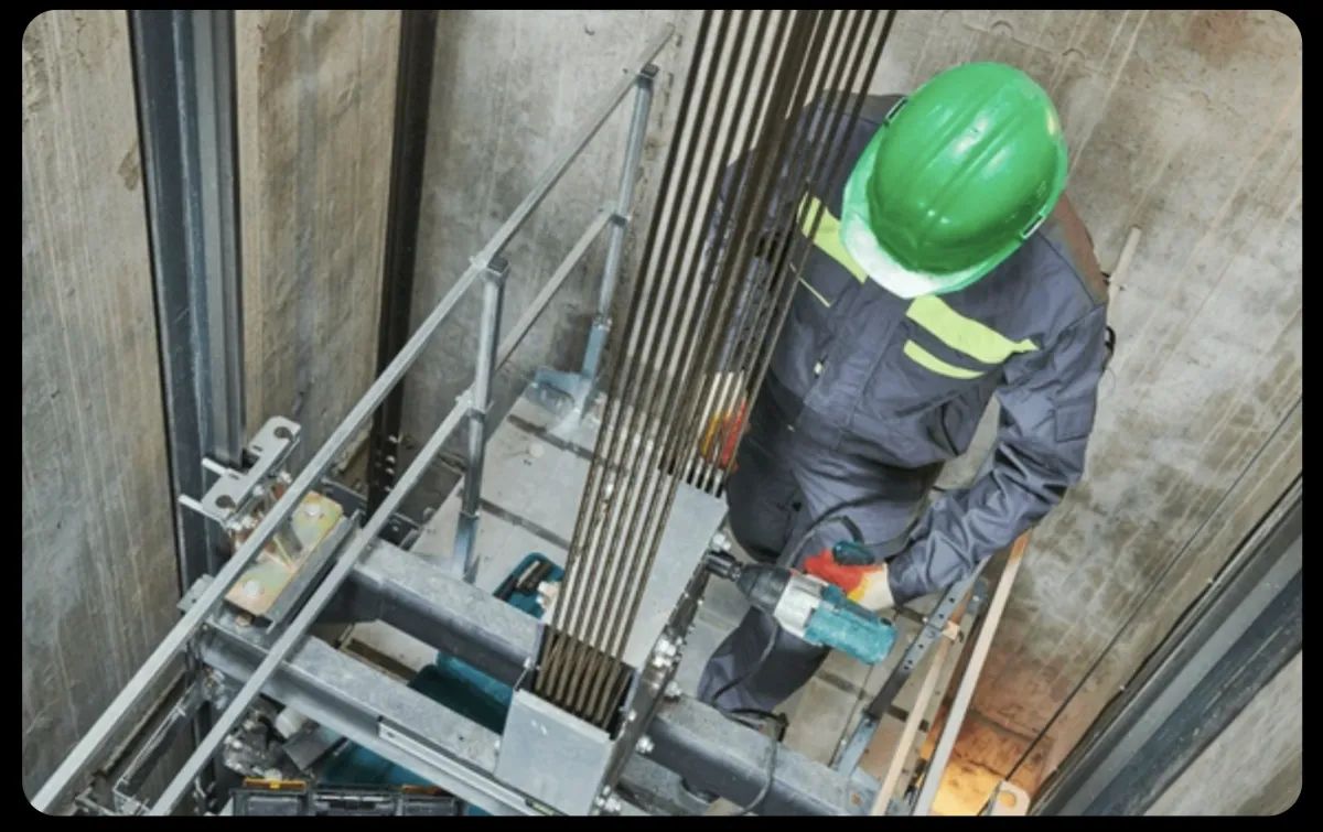 Elevator repair technician working in elevator shaft
