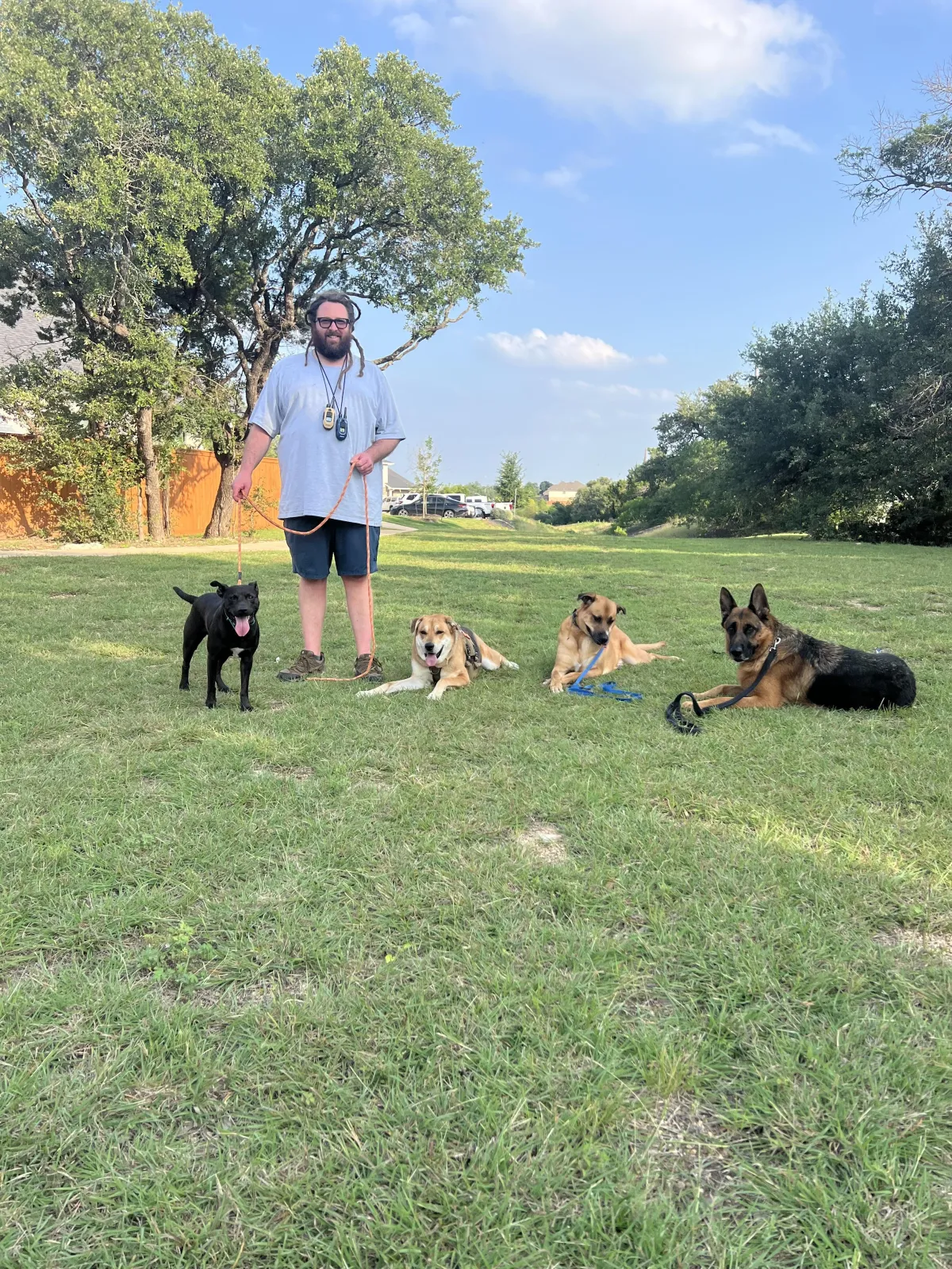 Sean Demers outdoors with several dogs trained through Hill Country K9