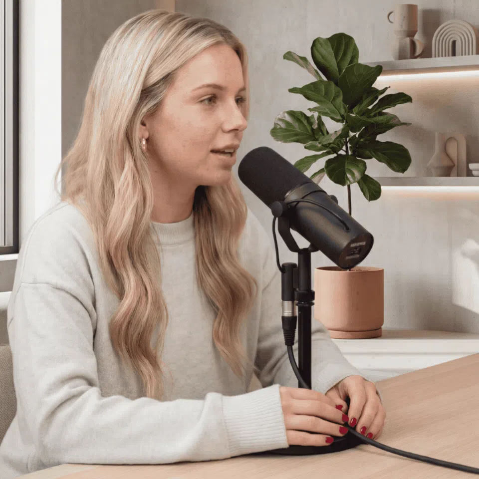 Woman speaking into a podcast microphone