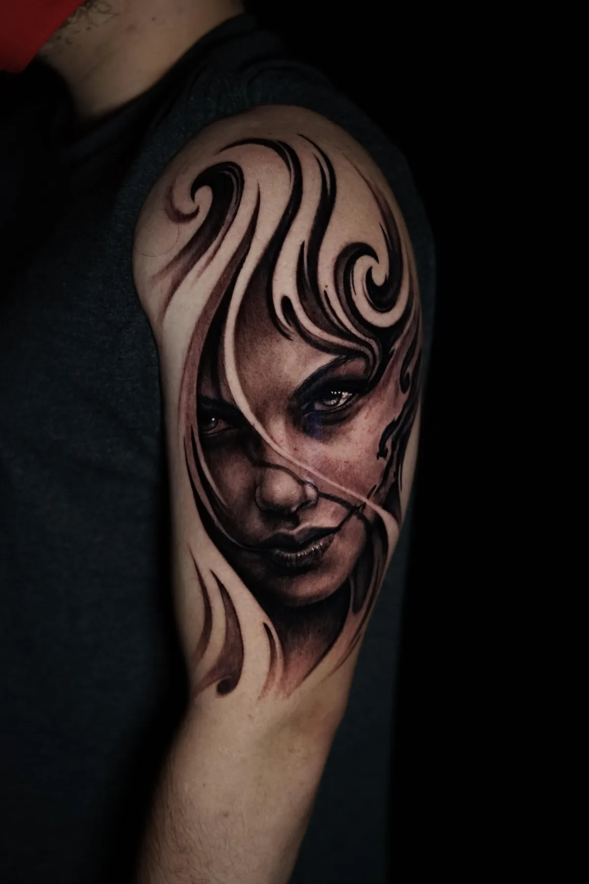 Black and grey female portrait tattoo with flowing abstract shapes and high-contrast eye detail by James Strickland in Missoula Montana