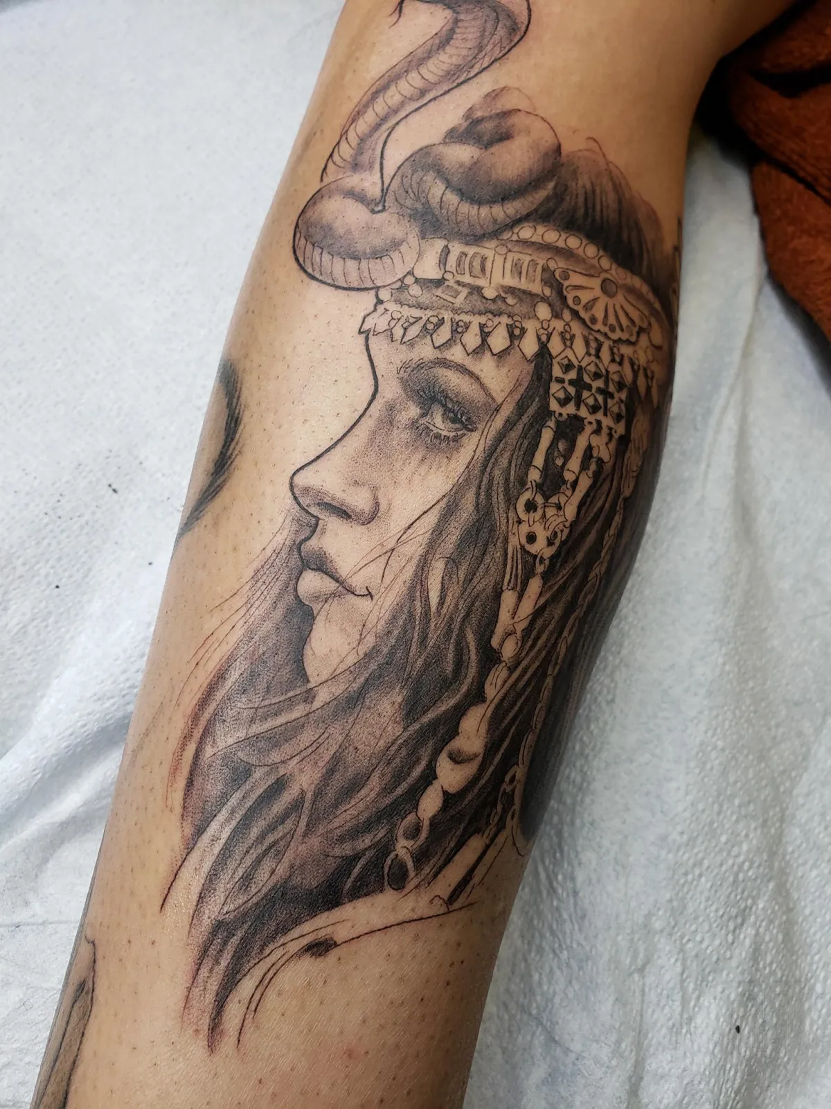 Black and grey illustrative woman portrait and snake tattoo by Mickey Schlick