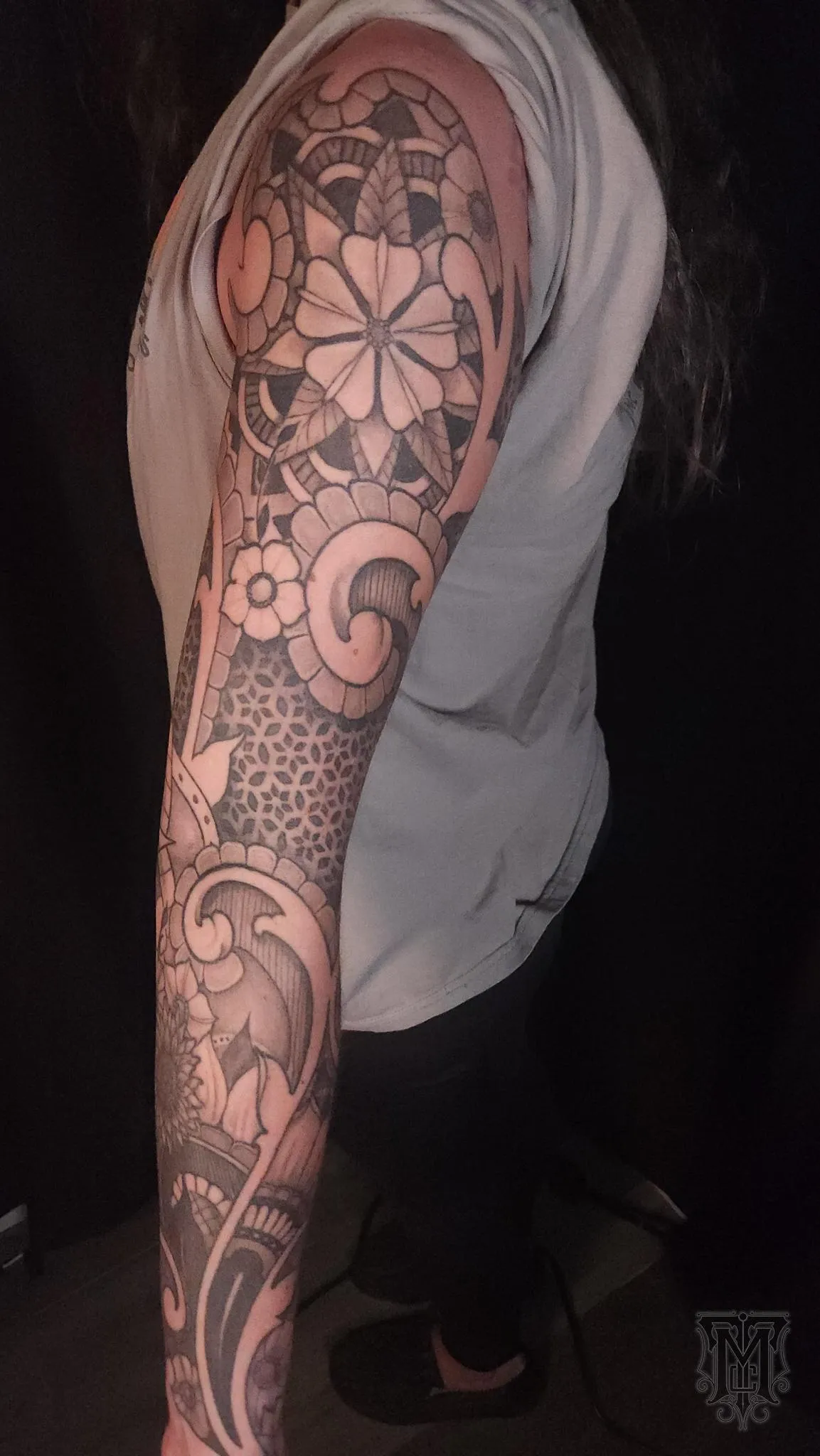 Black and grey geometric floral sleeve with ornamental wave patterns by Mickey Schlick