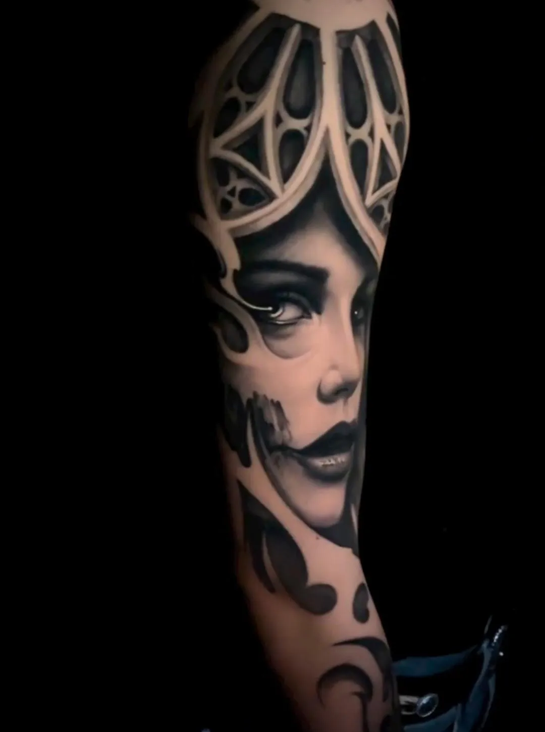 Black and grey gothic female portrait tattoo with geometric crown-like framing and high-contrast shading by James Strickland in Missoula Montana
