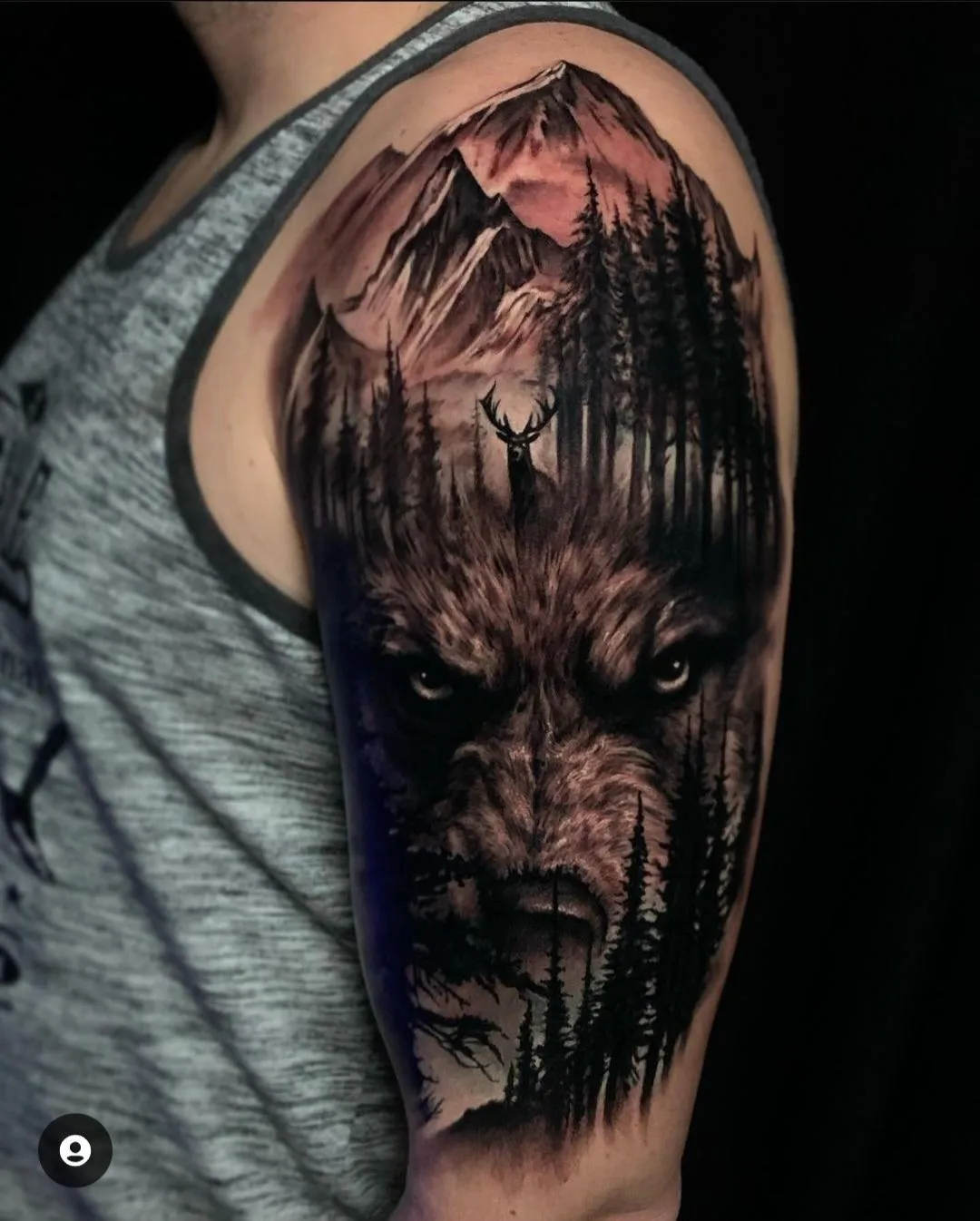 Black and grey wolf tattoo with mountain landscape, forest silhouettes and wildlife imagery by James Strickland in Missoula Montana
