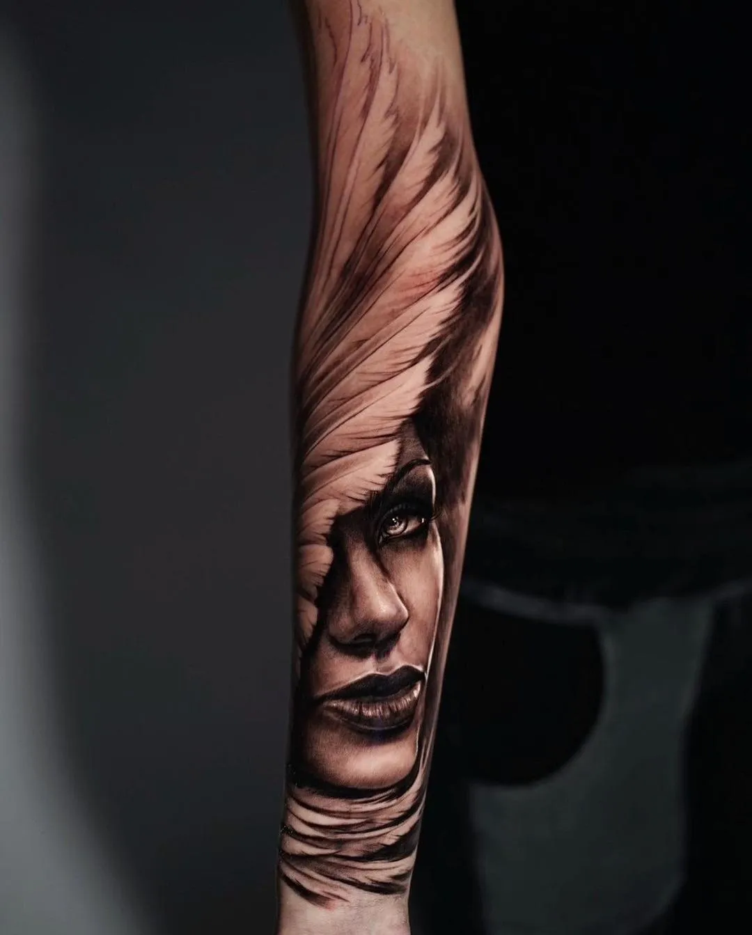 Black and grey forearm portrait tattoo of a woman framed by sweeping wrapped forms by James Strickland in Missoula Montana