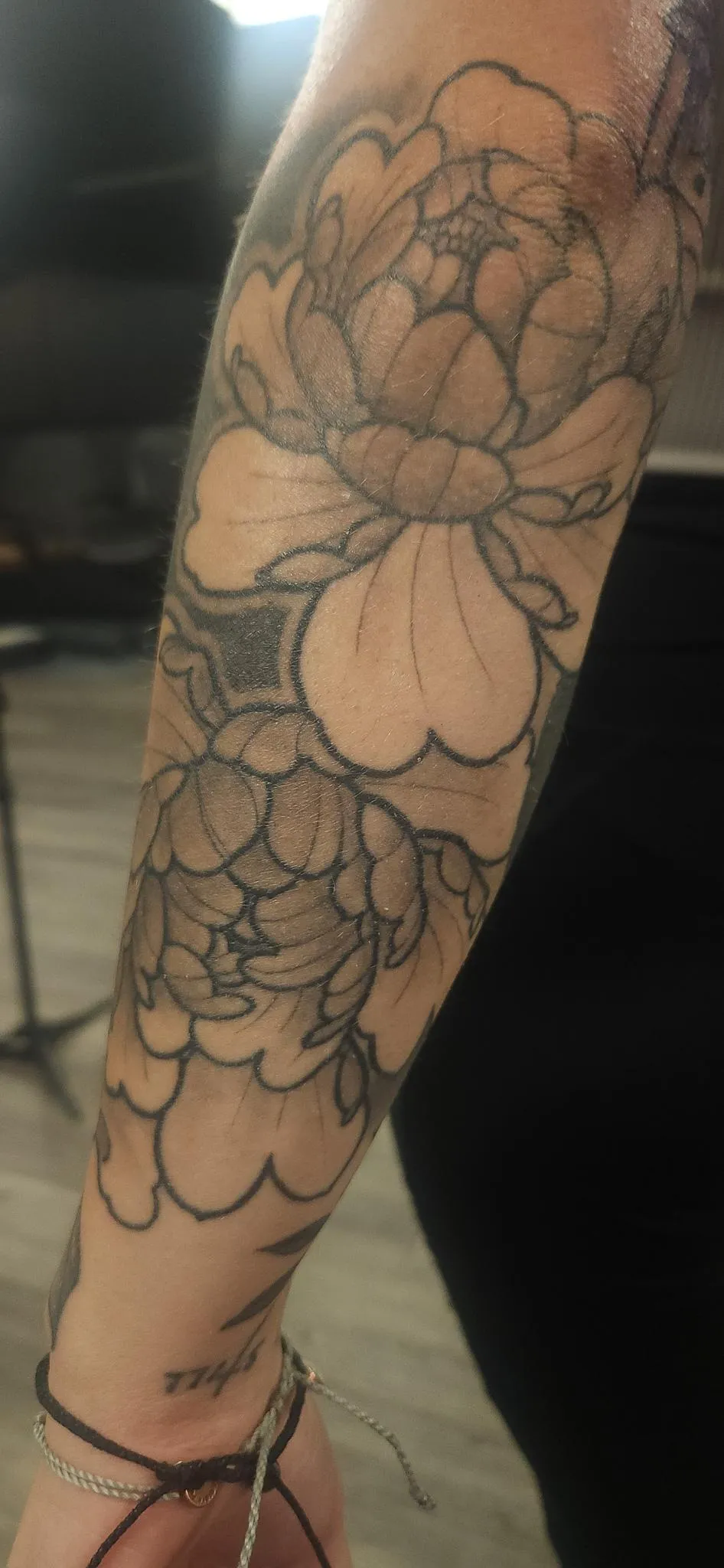 Large floral linework tattoo with layered peony style flowers by Mickey Schlick