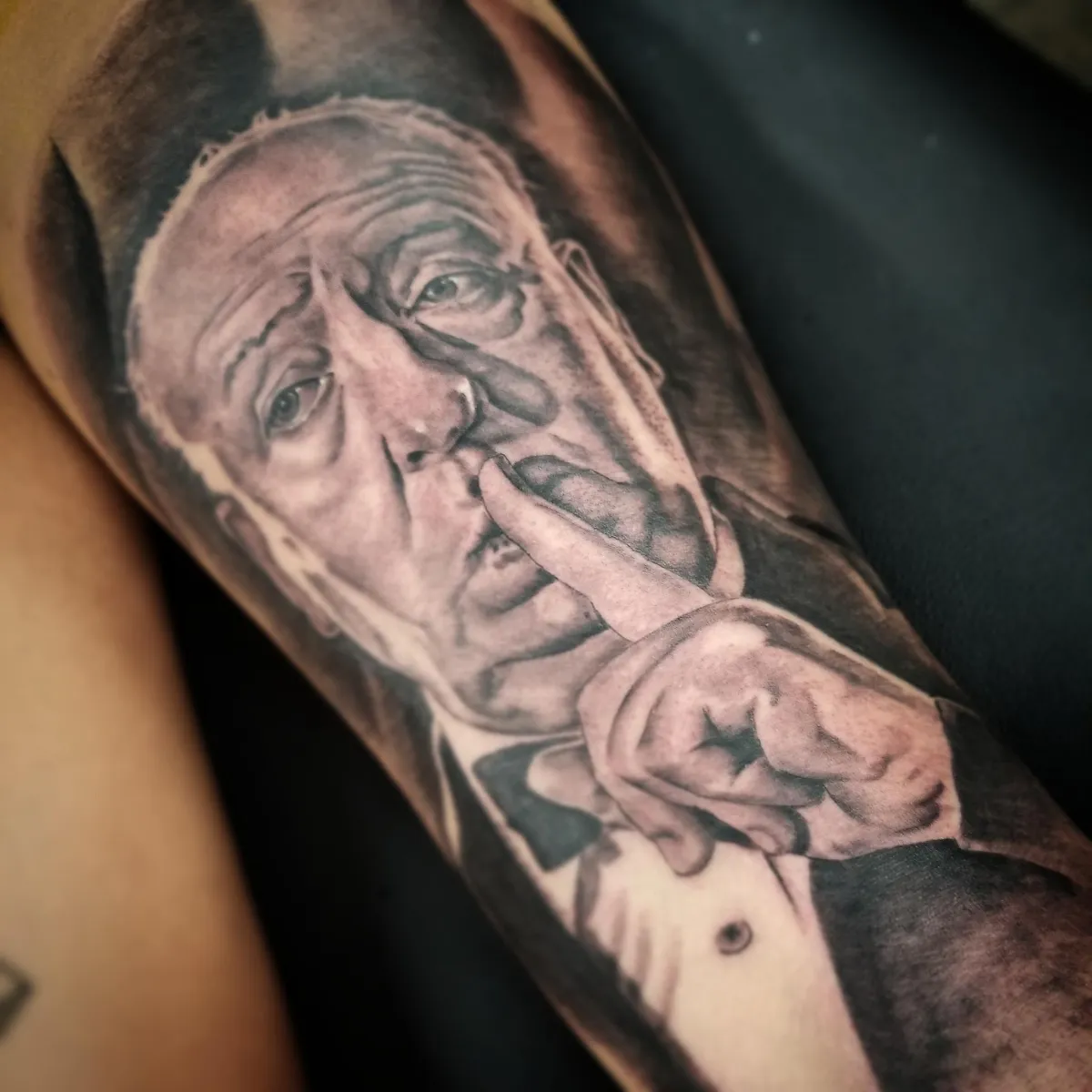 Black and grey surreal portrait tattoo with distorted face and hand gesture by Mickey Schlick