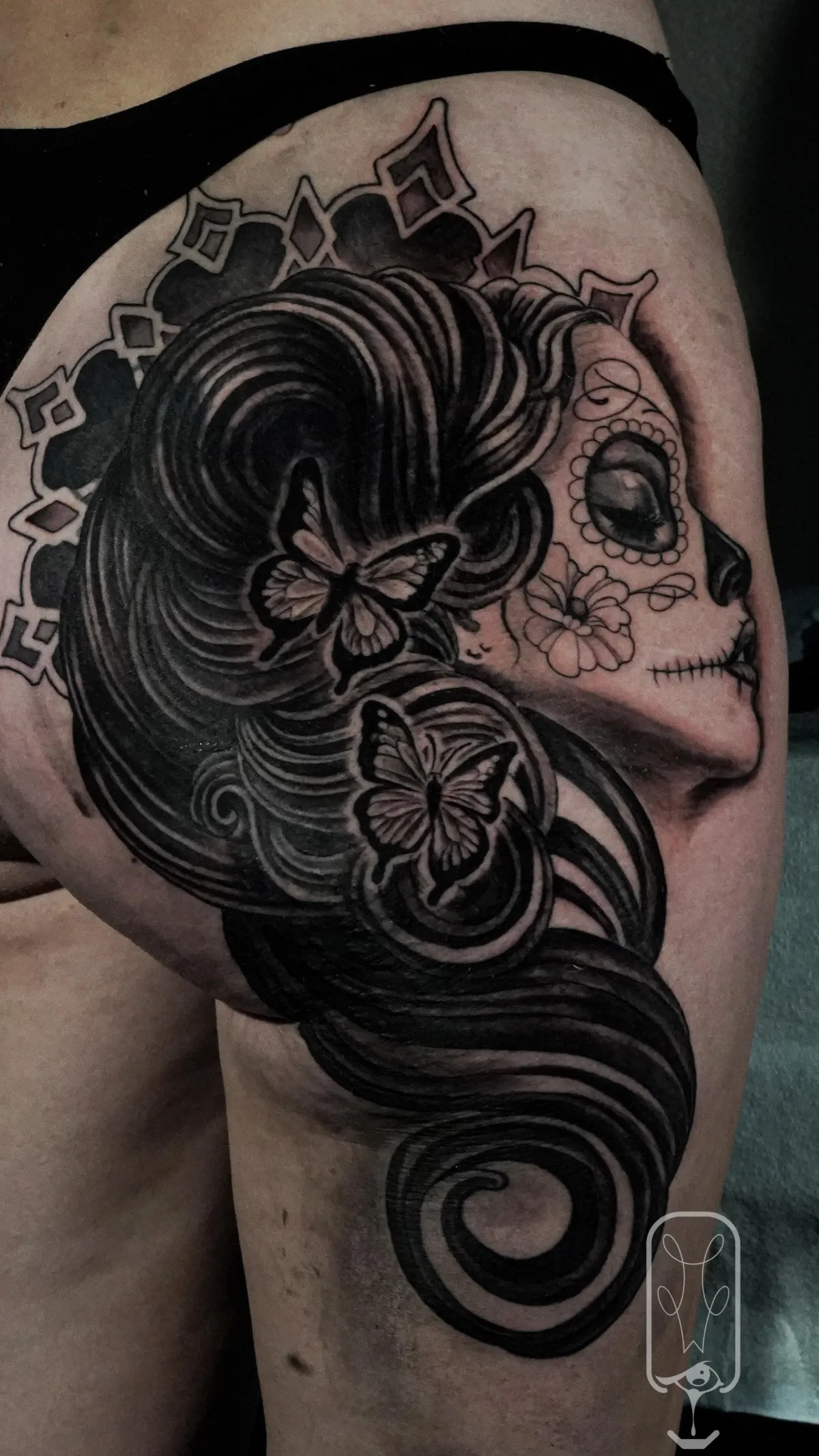 Black and grey sugar skull woman tattoo with butterflies and flowing hair by Mickey Schlick
