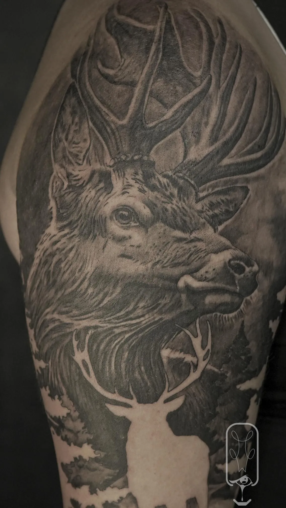 Black and grey elk portrait tattoo with layered antlers and forest imagery by Mickey Schlick