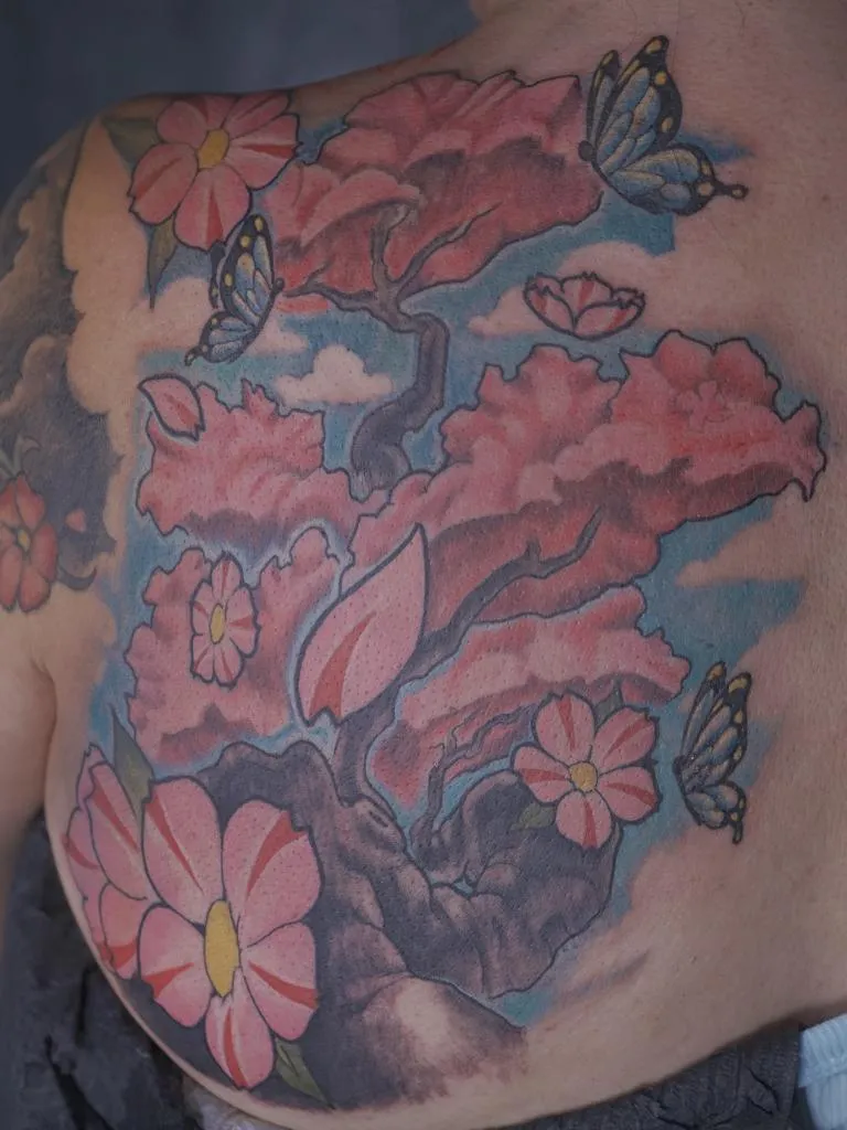 Color Japanese inspired floral back tattoo with butterflies and pink blossoms by Mickey Schlick