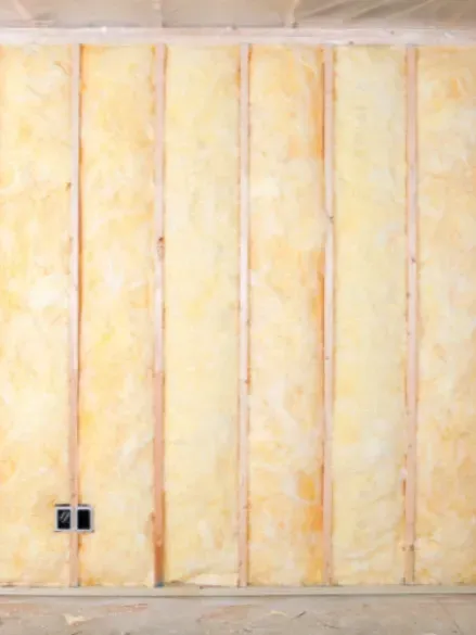 Fiberglass batt insulation fitted between wall studs