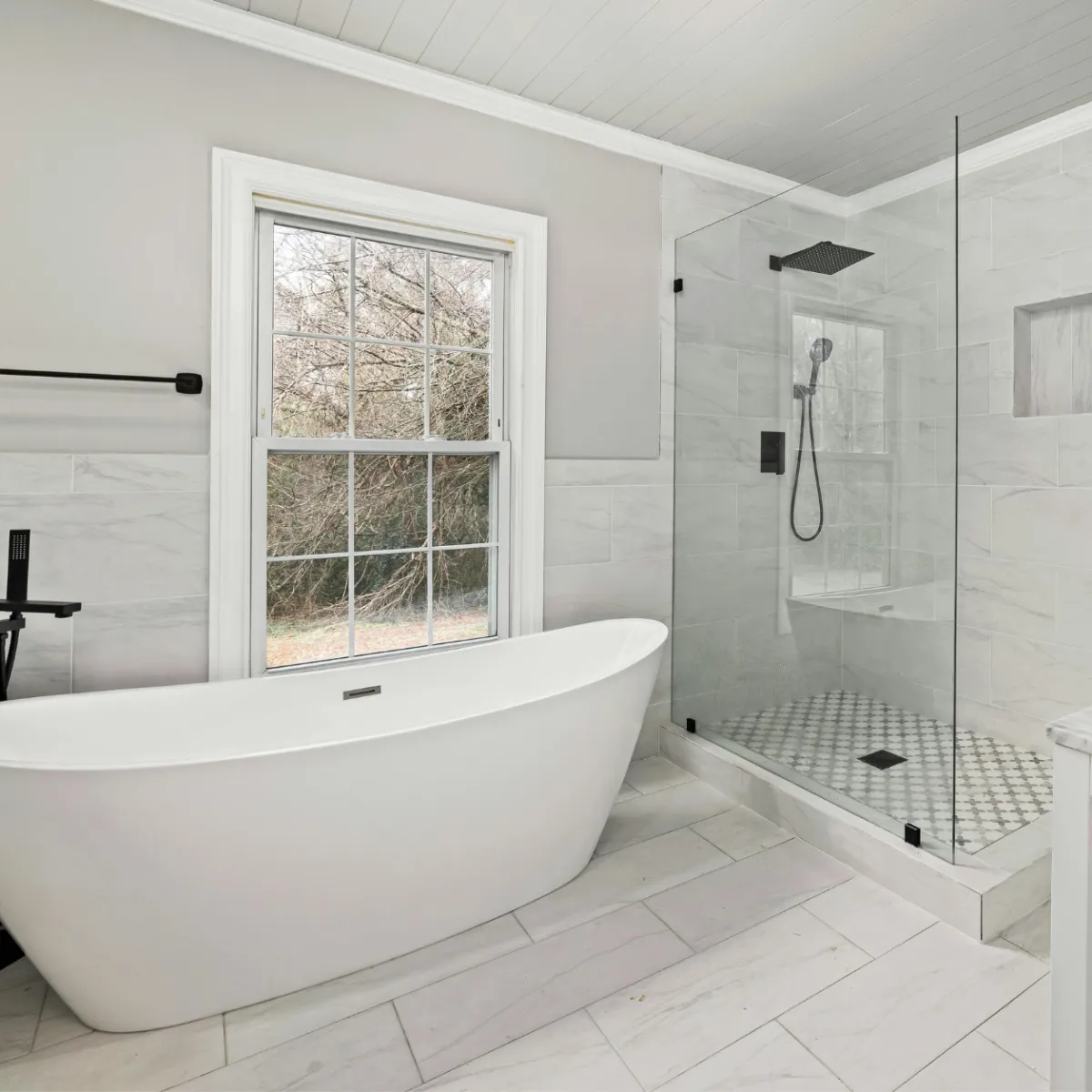Luxury bathroom remodeling in Fort Worth featuring freestanding tub, walk-in glass shower, and contemporary tile work.
