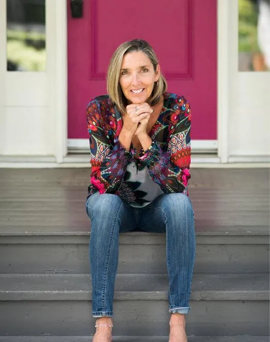 Michelle Cameron Coulter sitting on a porch step, looking at the camera with her ands under her chin.