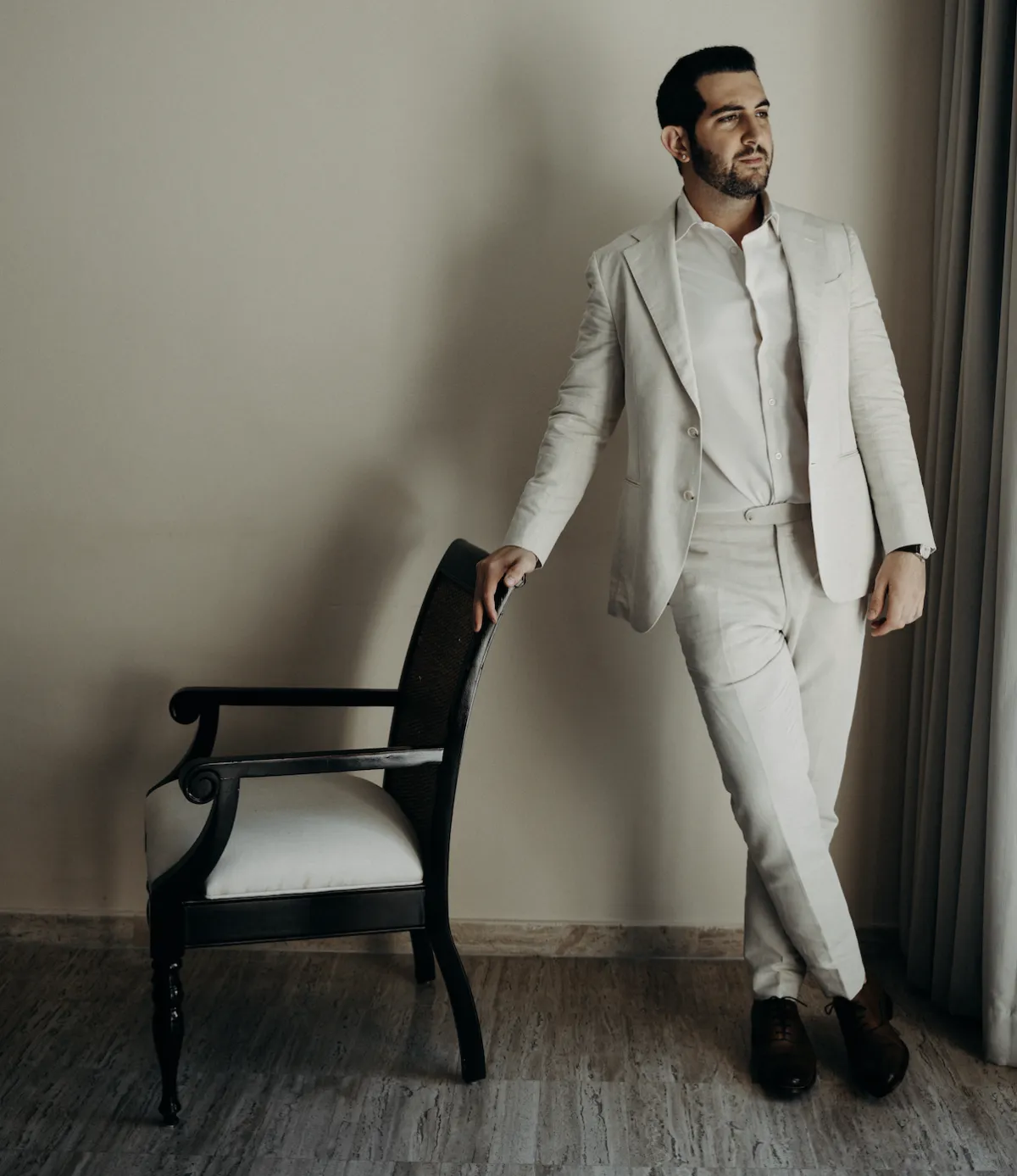 Portrait of Gil Golan, founder of Zenith Marketing Group, wearing a light-coloured suit standing confidently indoors