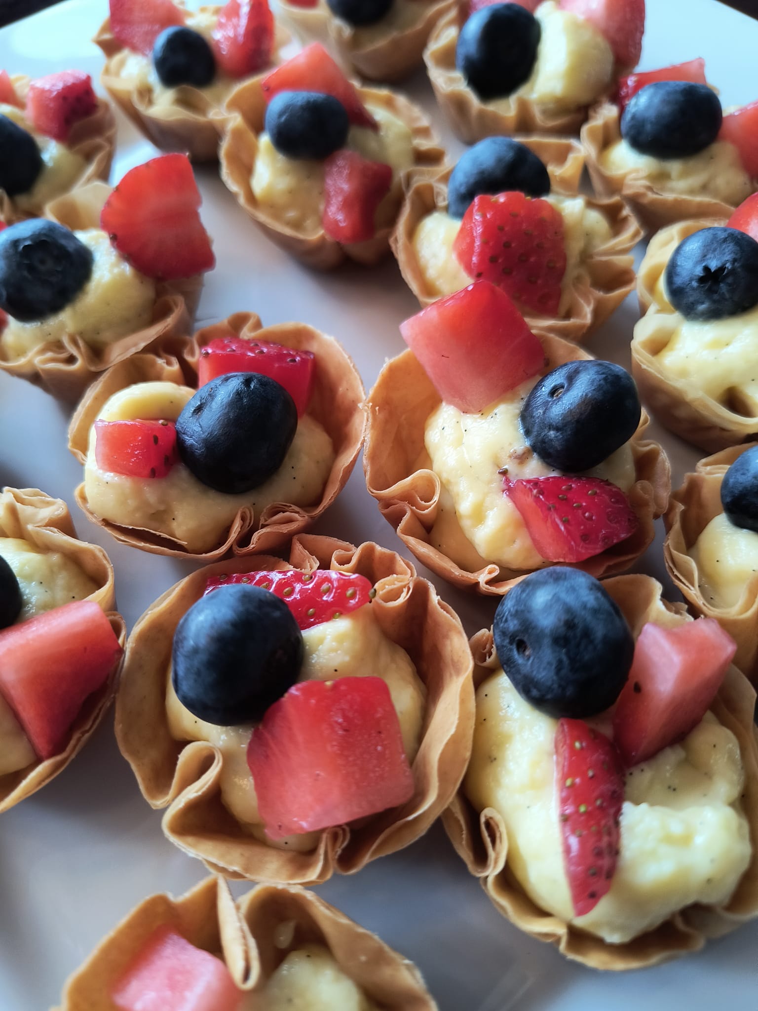 Mini fruit tart dessert bites with blueberries, strawberries, and custard prepared by Foodie Call private chef and catering service