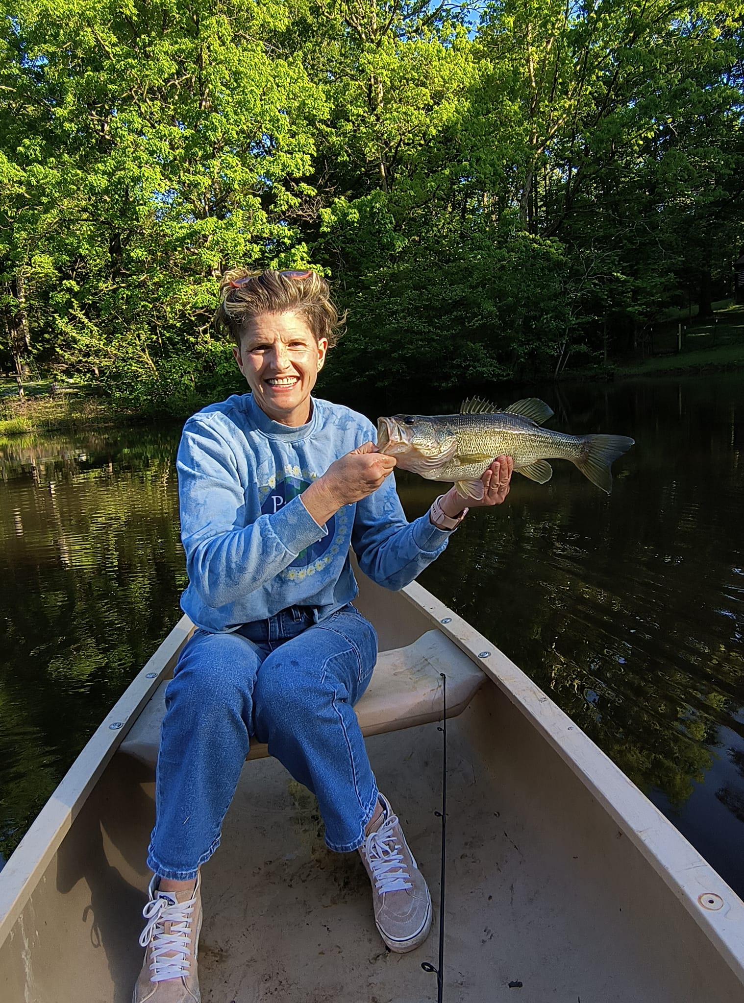 Chef Brandy enjoying freshwater fishing on a peaceful lake, showcasing the outdoor lifestyle and culinary inspiration behind Foodie Call