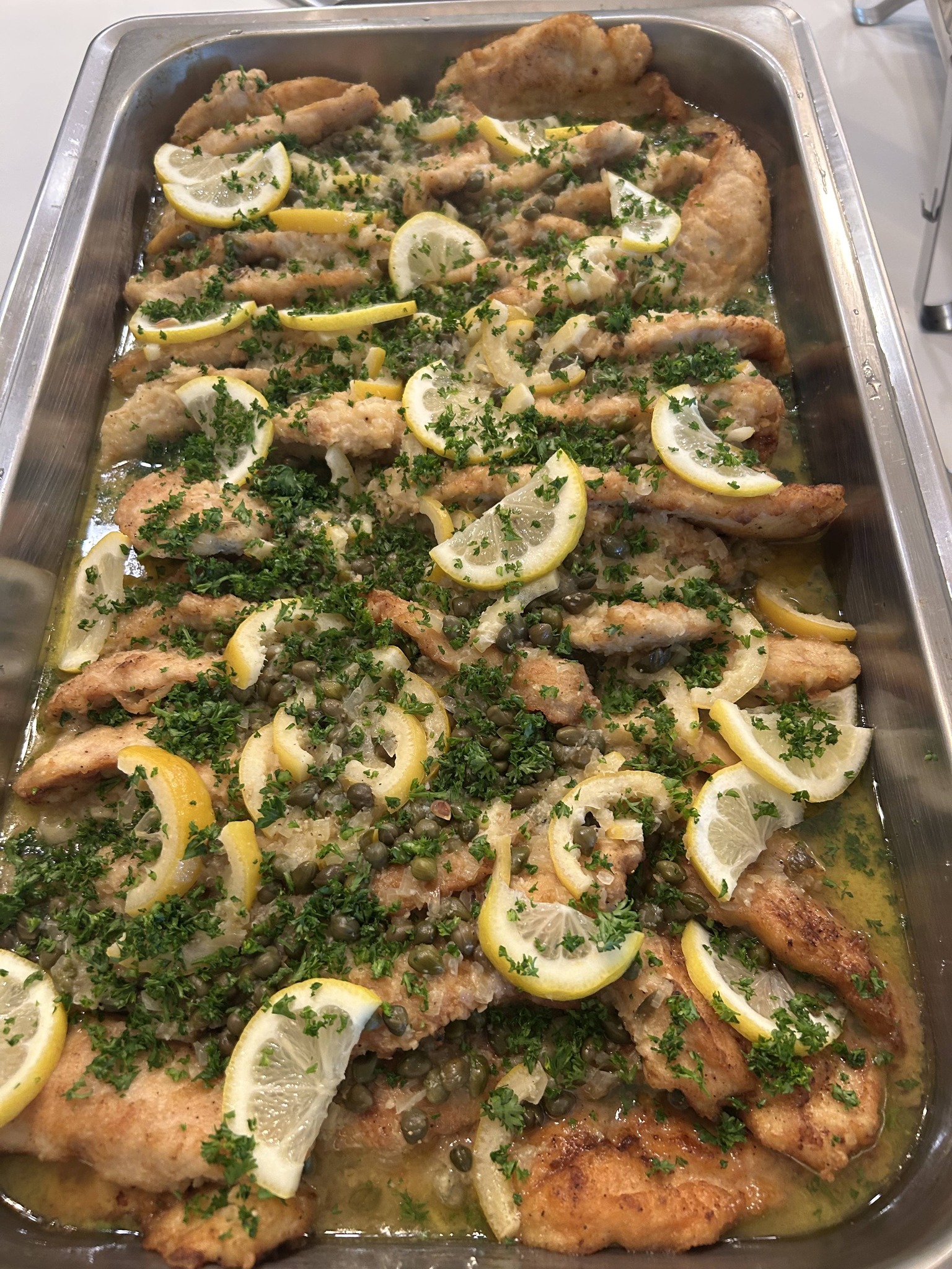 Lemon herb baked fish entrée served buffet-style for a Foodie Call catering event
