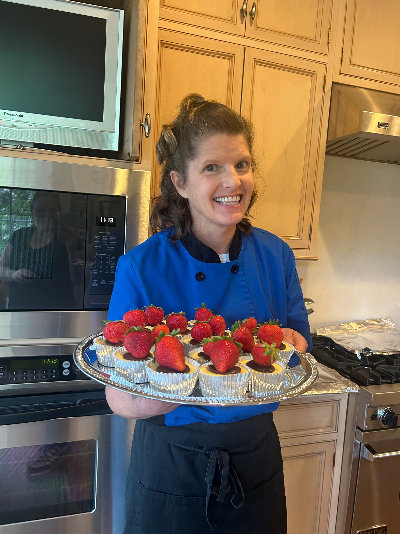 Professional private chef presenting chocolate-covered strawberry desserts in a luxury home kitchen for Foodie Call catering services