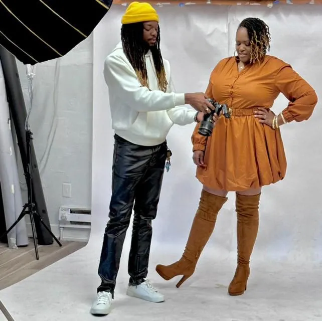 Photographer sharing a preview of elegant portraits on the back of the camera with a well-dressed woman during a refined, luxury photo session.