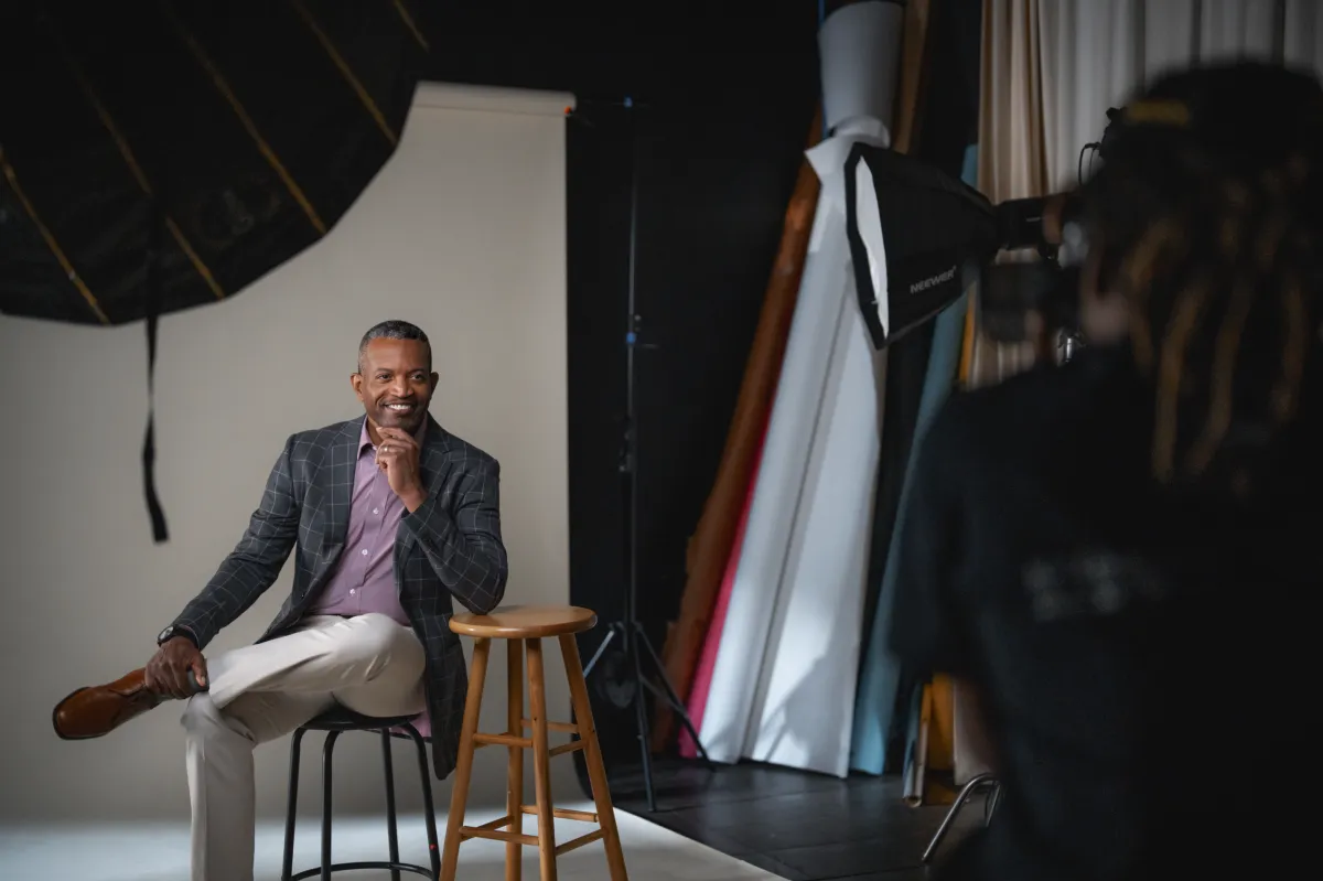 Photographer sharing a preview of elegant portraits on the back of the camera with a well-dressed woman during a refined, luxury photo session.