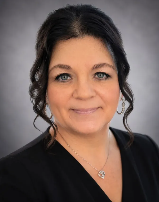 Massage Therapist Esthetician with brown hair smiling.