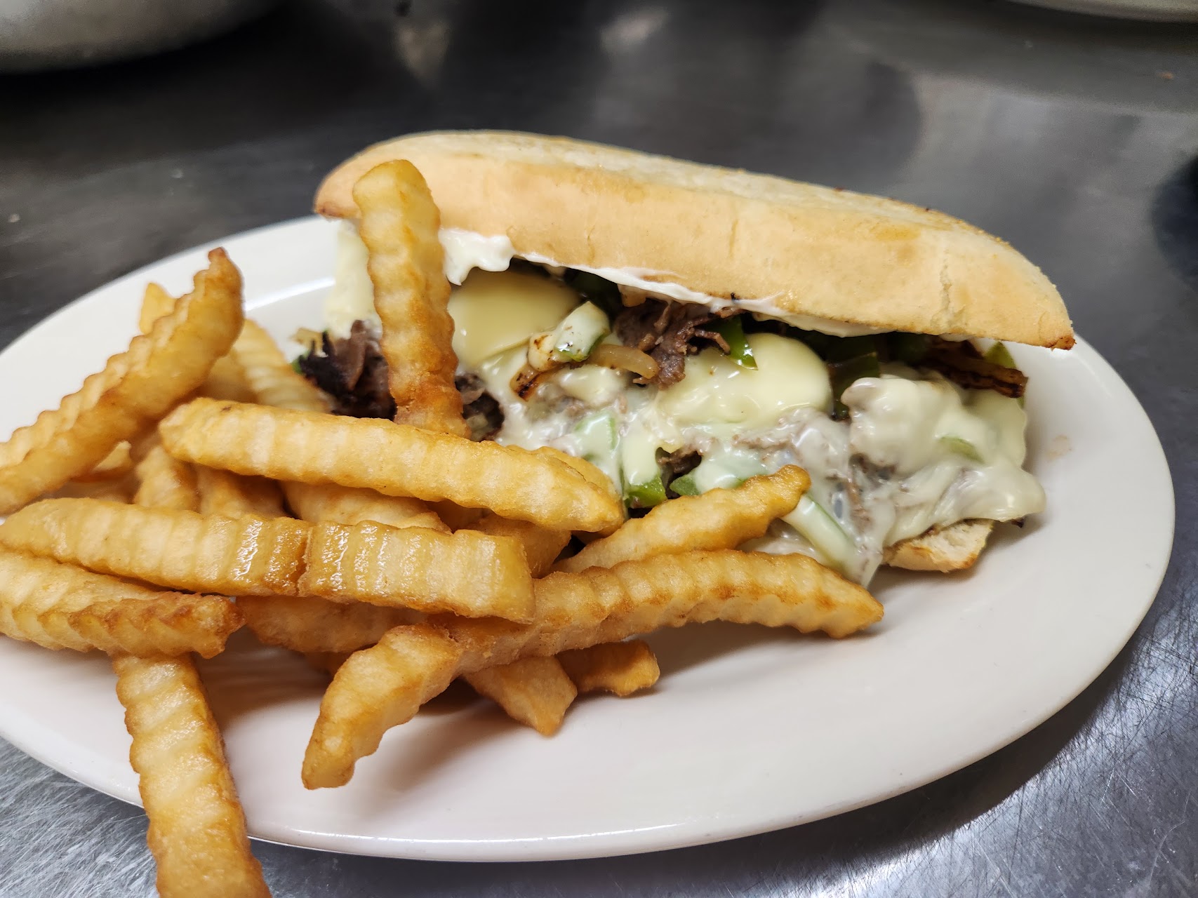 Philly sandwich with melted cheese and crinkle fries at MiMi’s Place