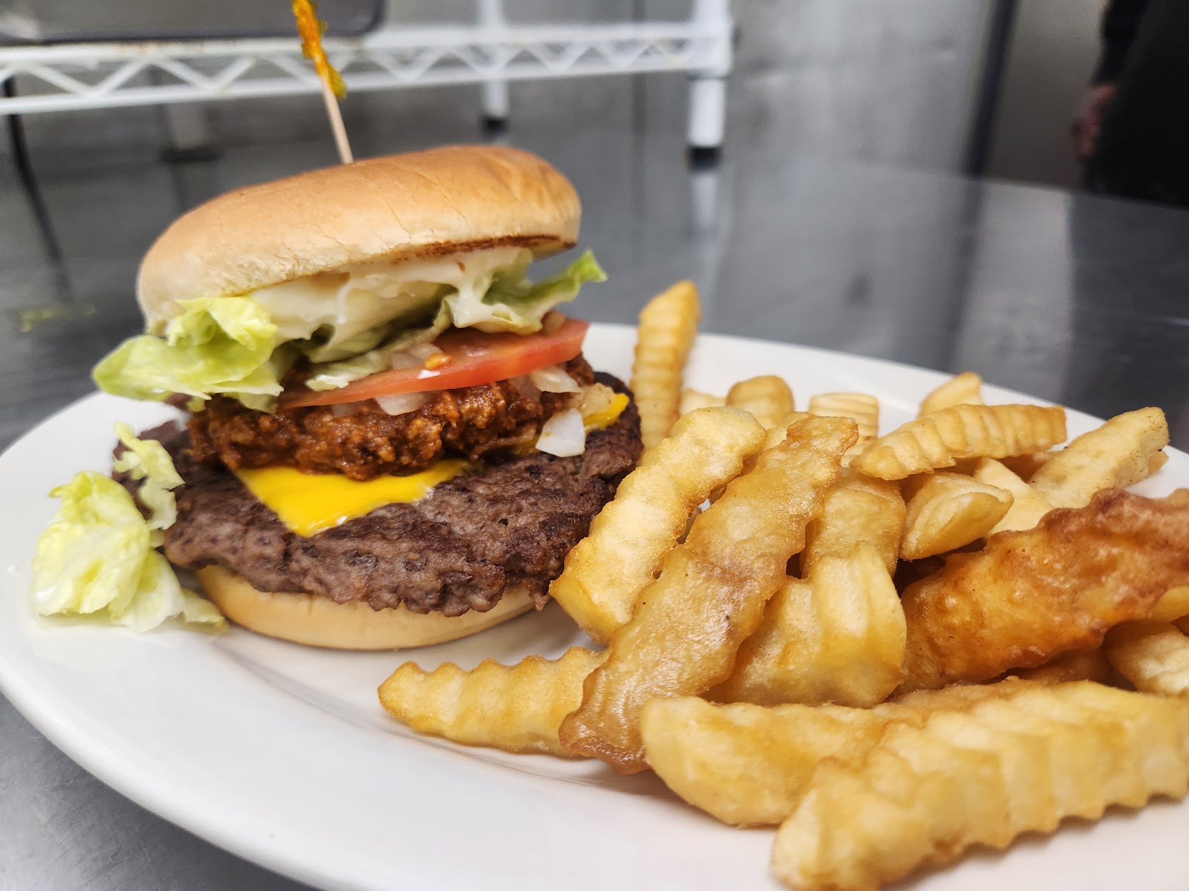 Burger with lettuce and tomato served with crinkle fries