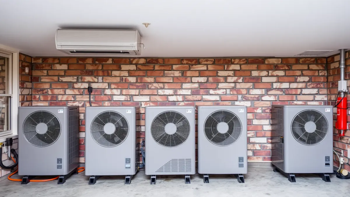 Modern air conditioning unit interior in a professional workshop, showcasing metallic parts, organized tools, and clean workspace.
